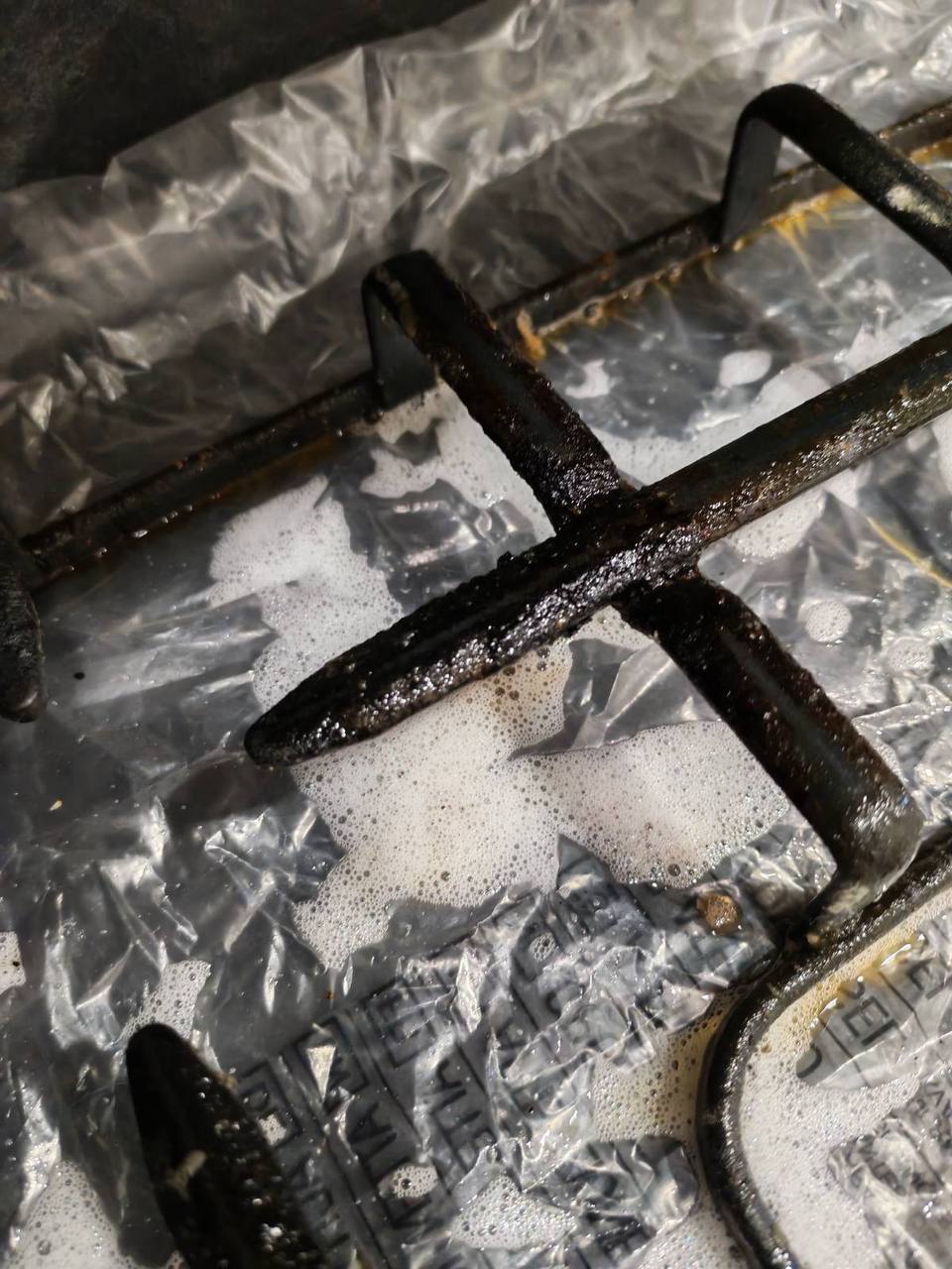 Решётка газовой плиты замачивается в моющем средстве — сложное загрязнение застарелым жиром